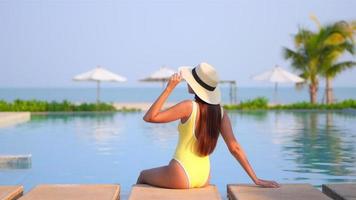 Young Asian Woman Relaxing Around an Outdoor Swimming Pool video