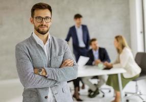 Hombre de gafas posado con equipo en el fondo foto