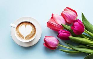 Coffee cup with latte art and tulips photo