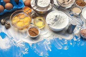 Baking ingredients on blue color background top view photo