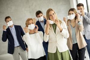 Group of professionals putting on masks photo