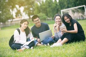 grupo de estudiantes asiáticos que estudian en la hierba