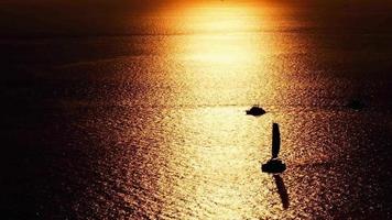 silhouet van een luxejacht en een zeilboot op een tropische zonsondergang tijdens het zomerseizoen