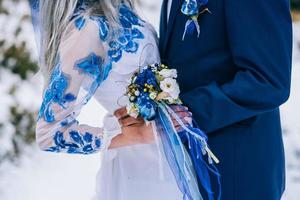 El novio en un traje azul y la novia en blanco en las montañas de los Cárpatos. foto