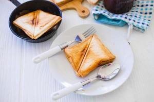 Roasted toast bread popping up of a stainless steel toaster in a home kitchen. photo