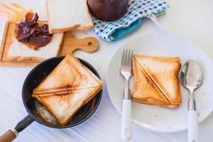 Roasted toast bread popping up of a stainless steel toaster in a home kitchen. photo