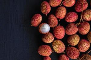 Fresh lychee fruit on a black wooden background. photo