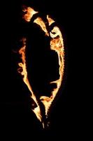 Corazón ardiente con llamas aislado sobre fondo oscuro foto