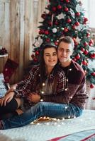 Guy and a girl celebrate the new year together and give each other gifts photo
