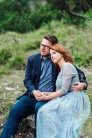 Young couple on a walk near the lake surrounded by the mountains photo