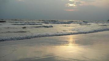 onde sulla spiaggia con il riflesso della luce solare sulla superficie della sabbia, con audio