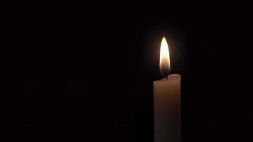 Close up Of a Single Candle Flame Burning Against a Black Background