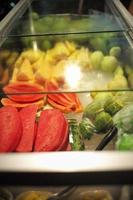 Various fruits in a glass cooler at a street food stall at a night market. photo