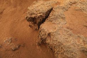 Rocky shore with red sand of the Mediterranean Sea photo