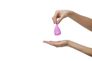 Young holding a pink menstrual cup on white background photo