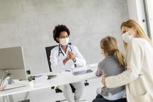 Pediatrician talking with patient with masks on photo