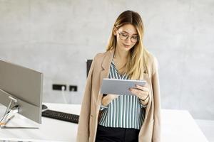 La empresaria usando una tableta en una oficina moderna