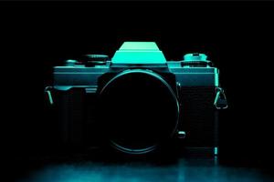 Low key image of a vintage film camera in turquoise color photo