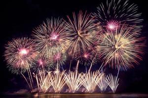 Festive beautiful colorful fireworks display on the sea beach Amazing holiday fireworks party or any celebration event in the dark sky photo