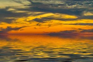 paisaje desde una altura con vistas al mar y una brillante puesta de sol foto