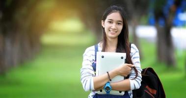 Smiling student holding laptop photo