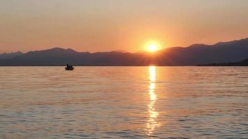 pêcheur sur le lac de garde au coucher du soleil video