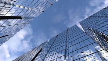 Animation de caméra de tours d'affaires parmi les immeubles de grande hauteur avec ciel bleu réfléchissant