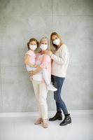 Vertical view of a grandmother, mother and child wearing masks photo