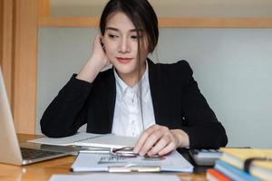 Businesswoman or accountants are working at the office to verify the accuracy of the account using a calculator and laptop computer photo