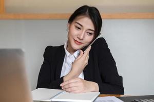 Businesswoman or accountants are calling and working at the office to verify the accuracy of the account using a calculator and laptop computer photo