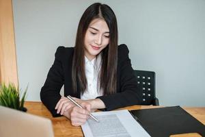 Businesswomen are working at the office to verify the accuracy of the account photo