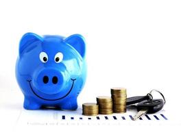 Blue piggy bank and money coins stack and car key for loans concept photo