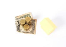 Pila de monedas de dólar y dinero con papel amarillo para el concepto de préstamos foto