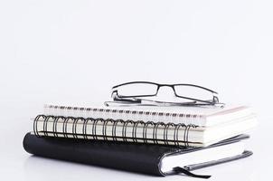 Eyeglasses on book stack for business concept photo