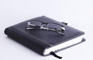 Eyeglasses on book for business concept photo