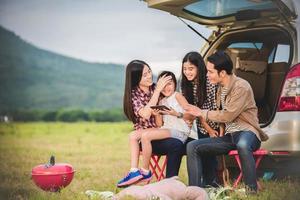 familia acampando fuera del coche en viaje por carretera foto