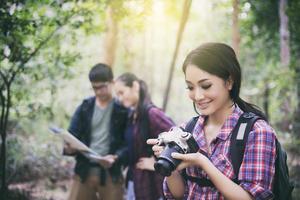 Group of young friends hiking in the woods photo