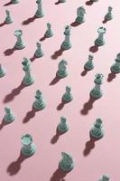 piezas de ajedrez blancas sobre fondo rosa foto