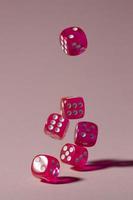 Falling pink dice on pink background photo