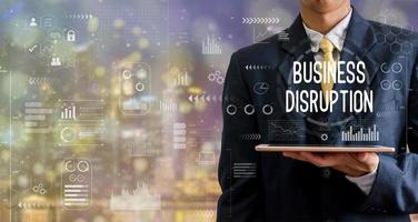 Businessman holding a tablet computer, business disruption icon, graph, abstract background with bokeh. photo