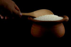 Scoop rice by using a ladle in a clay pot photo