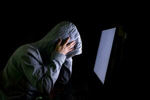 hacker de mujeres irrumpe en los servidores de datos del gobierno e infecta su sistema con un virus en su escondite, atmósfera azul oscuro, dama encapuchada que usa una computadora portátil con fondo de código binario, concepto de malware