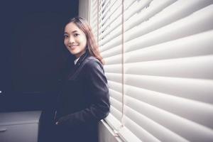 Woman posing next to office blinds photo