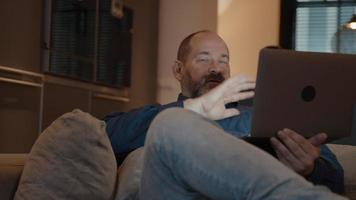 Mann, der Online-Anruf auf Laptop auf Couch hat video