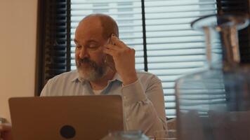 Man at table talking on smartphone video