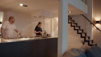 Man watching woman preparing meal in kitchen video