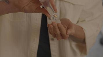 Woman with face mask using hand gel video