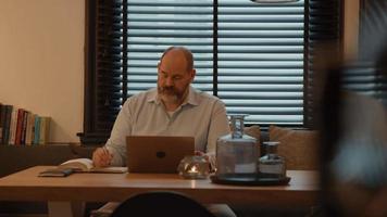 homem à mesa fazendo uma chamada online no laptop video
