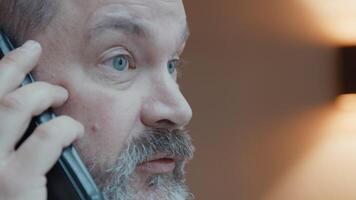Man looking through window whilst talking on smartphone video