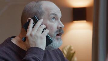 Man looking through window whilst talking on smartphone video